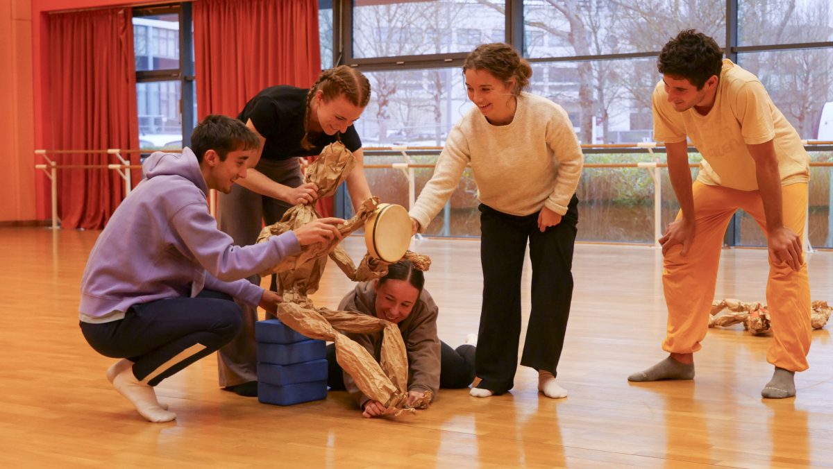 Les étudiantes et étudiants du groupe HArtCorps utilisent une marionnette en papier pour raconter une histoire.