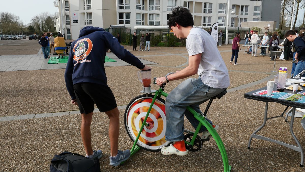 Un étudiant utilise le vélo smoothie pour faire un smoothie