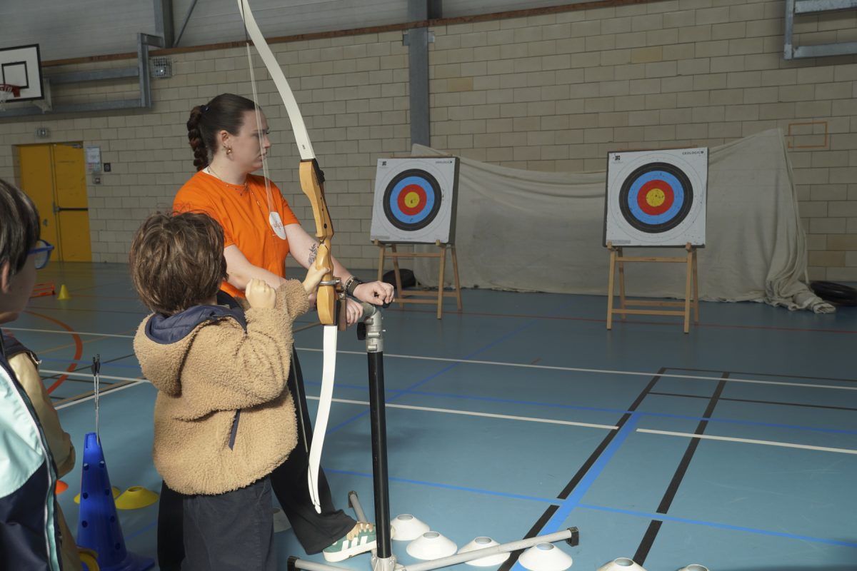 Un enfant fait du tirc à l'arc adapté