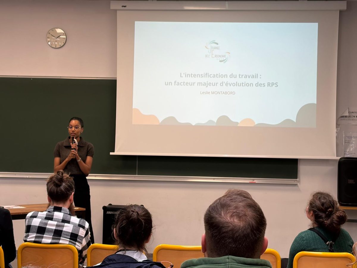 Leslie Montabord présentant sa conférence sur les risques psychosociaux avec l'intensification du travail face au public de la journée de l'ergonomie