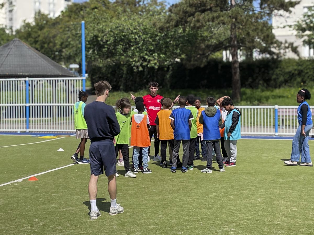 2 étudiants de L3 ES avec un groupe d'enfant en activité sportive sur un city